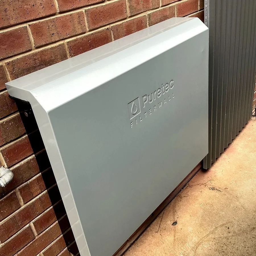 Air conditioning unit installed against a brick wall