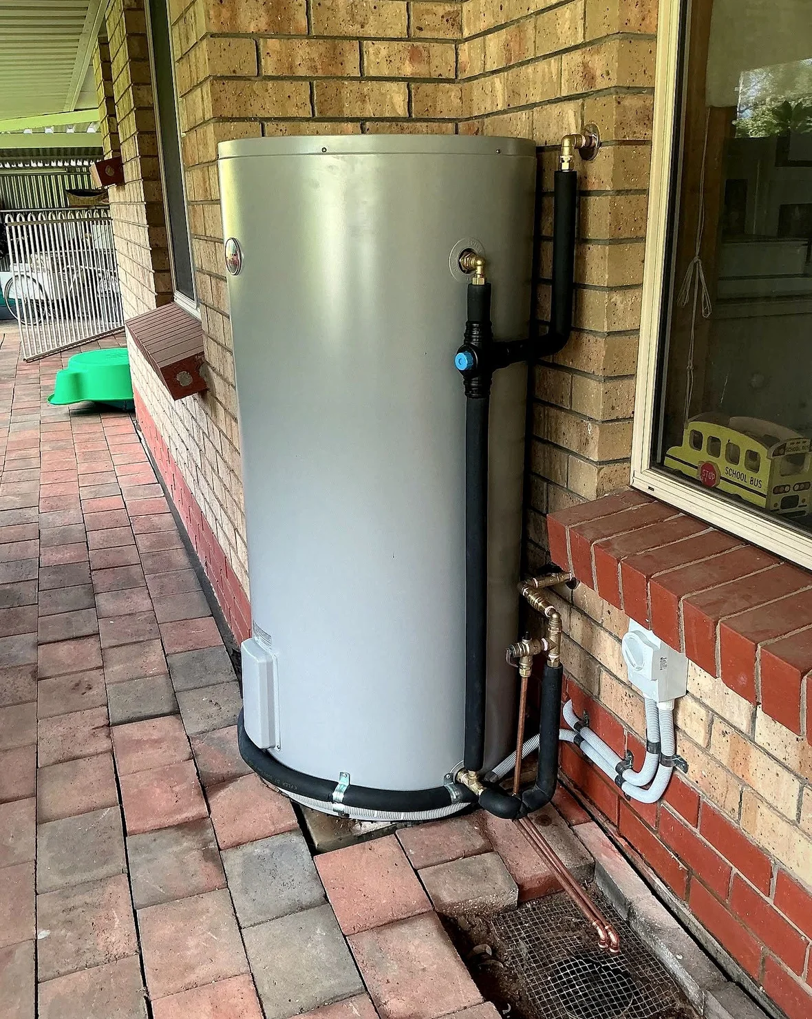 Hot water system installed by RHINO against a brick wall